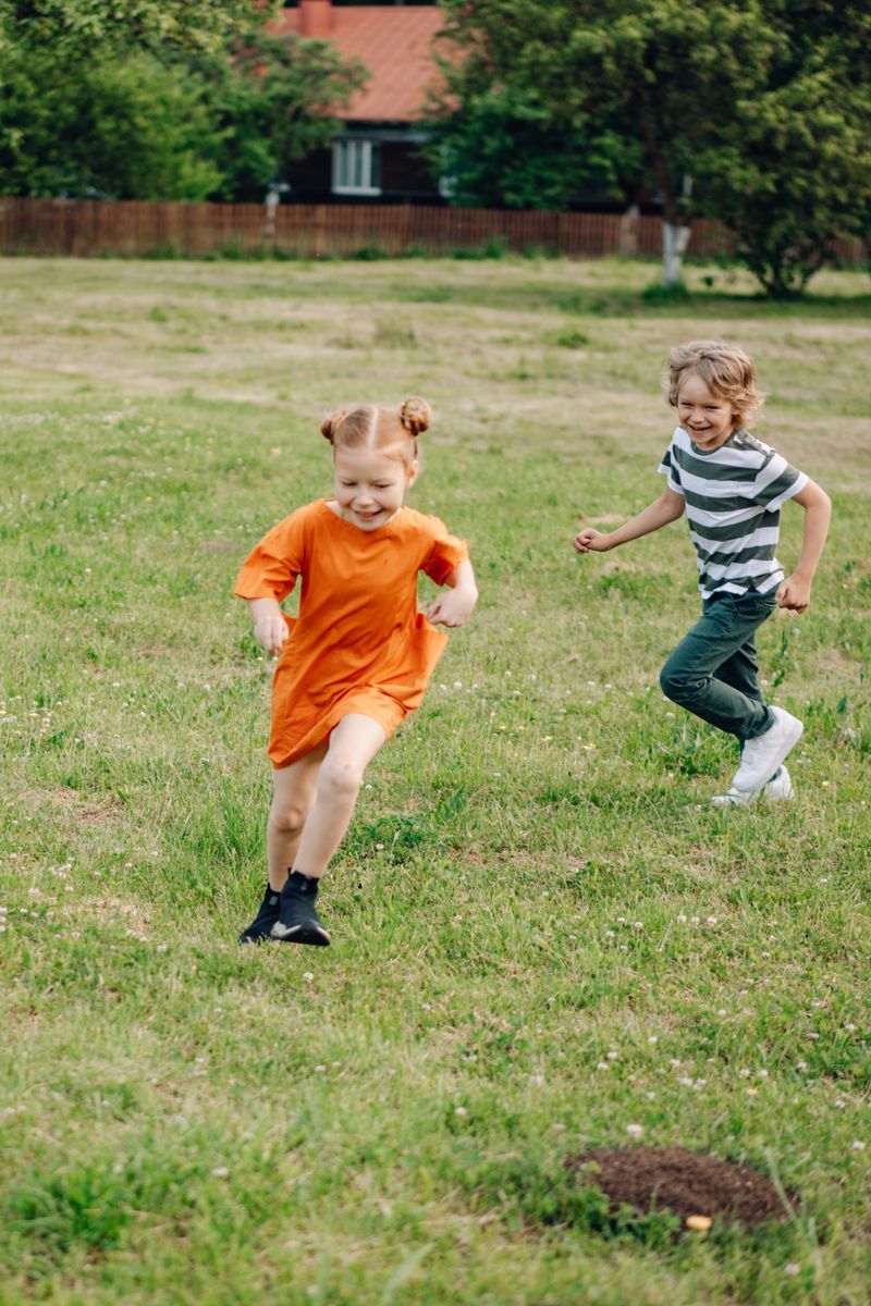 Dos niños corriendo en el pasto